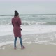 A Girl Stands on a Sandy Beach - VideoHive Item for Sale