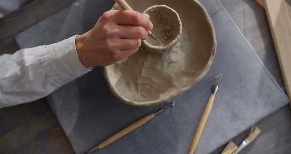 {Ceramist Carves a Pattern on a Raw Clay Potter Makes Texured Clay Surface Making the Ceramics at the