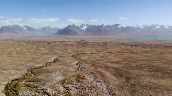 Top Aerial View of Tajikistan Landscape Alpine Blue Lake and Gravel Arid Desert Mountains in Sunny