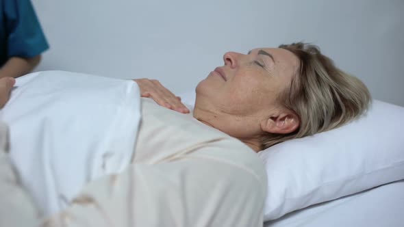 Sick Woman Suffering From Fever and Ravings, Nurse Putting Compress on Forehead