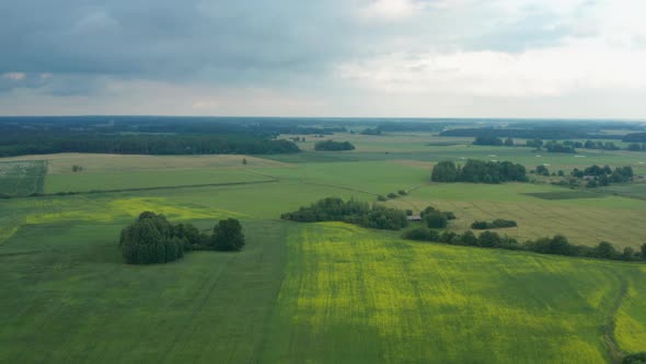 Spectacular landscape flight above green expansive flat plains and farmland in rural countryside on