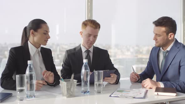 Businessmen Signing Contract in Meeting Room