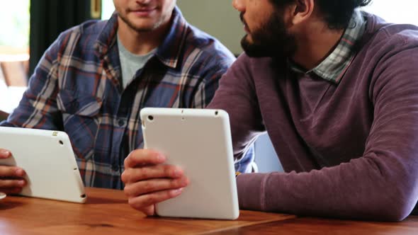 Friends using digital tablet and interacting with each other