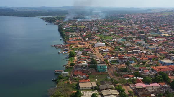 High angle aerial shot flying over the city of Altamira, Brazil. Smoke rising in the distance