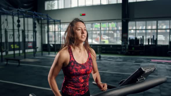 Woman athlete athlete is engaged in cardio training on the treadmill, thin beautiful sports girl