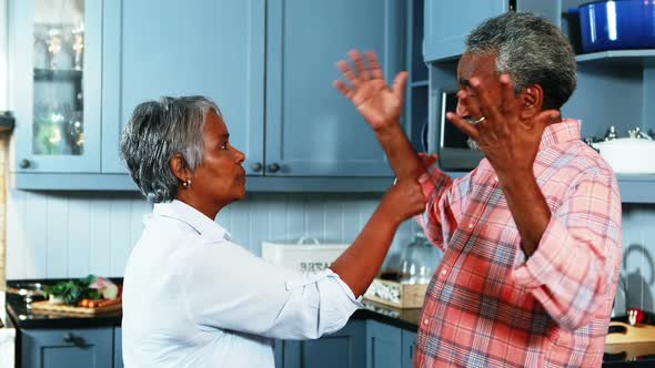 Senior couple quarrelling with each other in kitchen