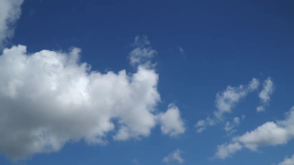 Time-lapse. The movement of white clouds against the blue sky