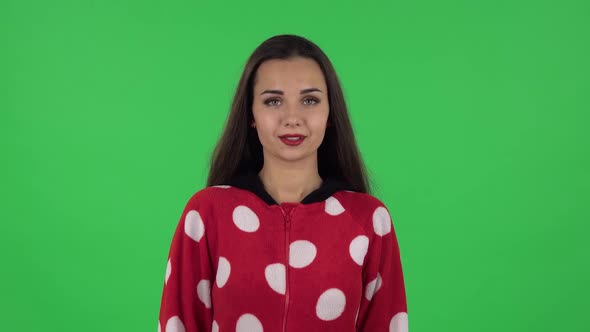 Portrait of Beautiful Girl in Red Fleece Pajamas Is Standing, Spreads Out in a Smile. Green Screen