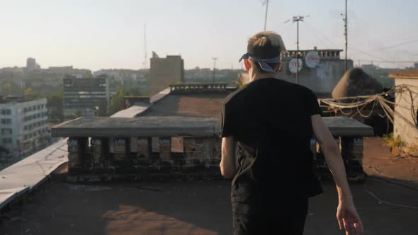 Parkour, a young guy running on the roof of an old high-rise building at sunset