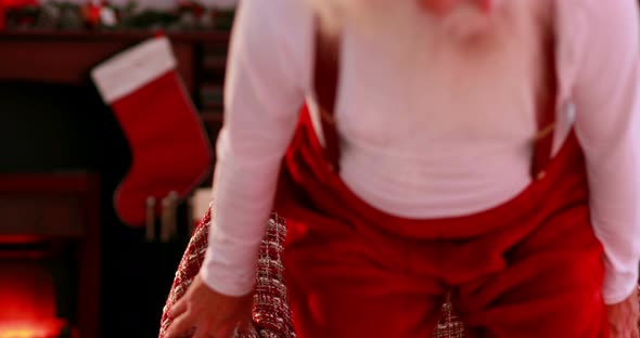 Tired santa sitting down in armchair 4k