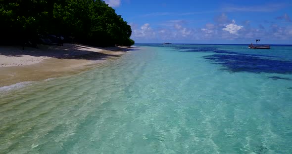 Wide drone travel shot of a white sandy paradise beach and aqua turquoise water background in vibran