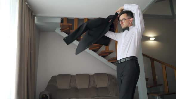 European man in room puts on jacket. Morning gathering prep groom. Slow Motion