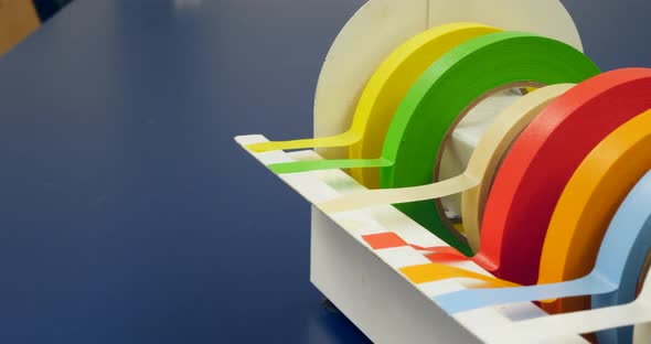 Close up on a scientist grabbing a piece of tape for an experiment in a medical research laboratory.