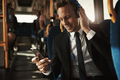 Smiling businessman listening to music during his morning commute - PhotoDune Item for Sale