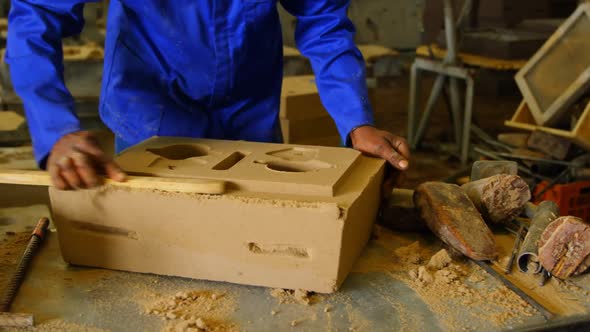 Mid section of worker making mold in foundry workshop 4k