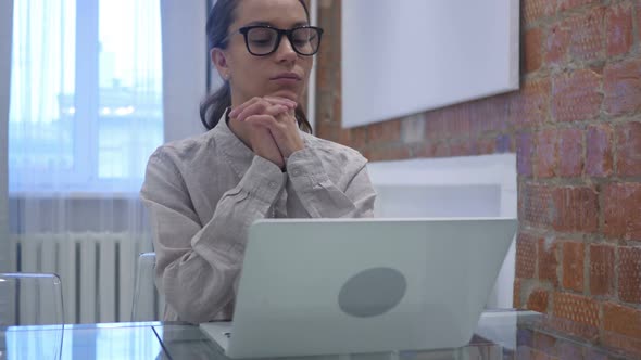 Pensive Hispanic Woman Sitting at Work in Office