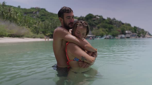 A Video Has Been Captured of a Romantic Couple Cuddling While Standing in a Sea Water and Smiling