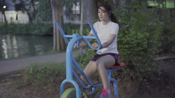 woman working out on the exercise bike in park