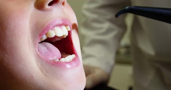 Dentist examining a young patient with dental tools