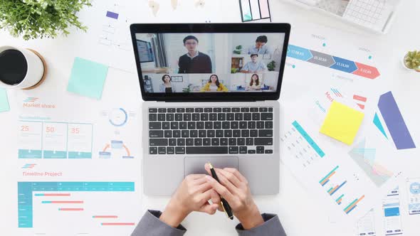 Top view of young Asia businesswoman using laptop talk to colleague about plan in video call.