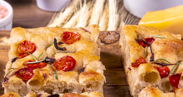 Homemade italian flat bread - Focaccia contorta. With olives, olive oil, rosemary, tomatoes. Traditi