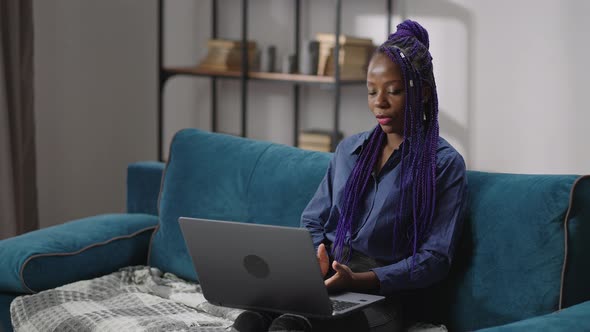 Distant Job Interview for Young Black Woman By Video Conference in Laptop Woman is Sitting on Couch