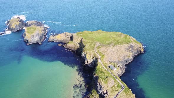 Slow Aerial Fly Over Carrick-a-Rede Rope Bridge on a Sunny Day