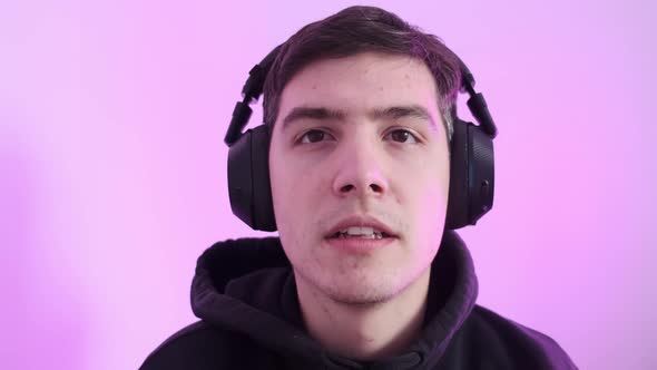 A Young Man Puts on His Wireless Headphones and Plays Computer Games