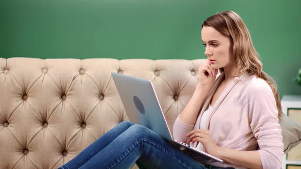 Pensive Freelancer Woman Working Remotely Sitting on Couch at Home