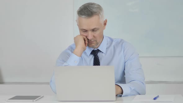 Tired Senior Businessman with Neck Pain in Office