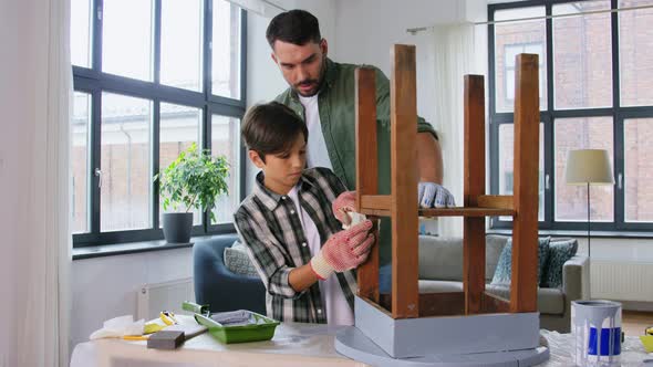 Father and Son Sticking Adhesive Tape to Old Table