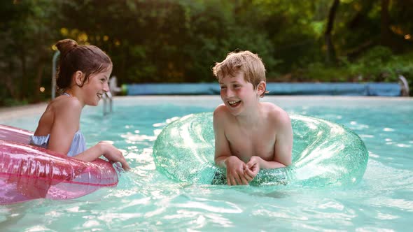 Two Kids Boy and Girl Having Fun in the Pool