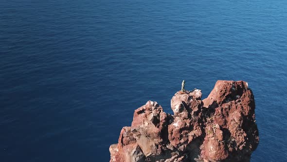 Aerial View on High Rock and Statue on Its Peak in Mediterranean Sea Against Horizon. Blue Sky