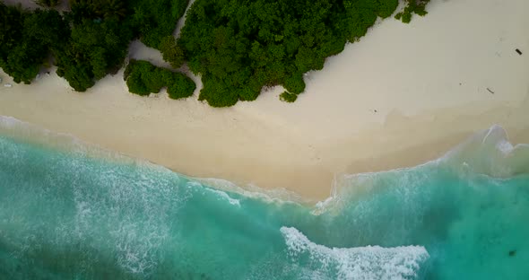 Daytime drone copy space shot of a white sandy paradise beach and aqua turquoise water background in