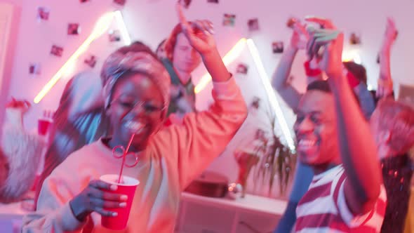 Joyous African American Couple Dancing with Friends at Home Party
