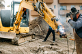 Construction worker welding broken excavator on construction site - PhotoDune Item for Sale
