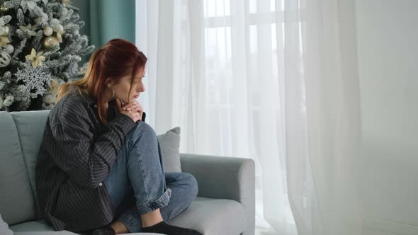 Desperate Redhead Woman Sitting Alone at Home on New Year's Eve. Portrait of Depressed Beautiful