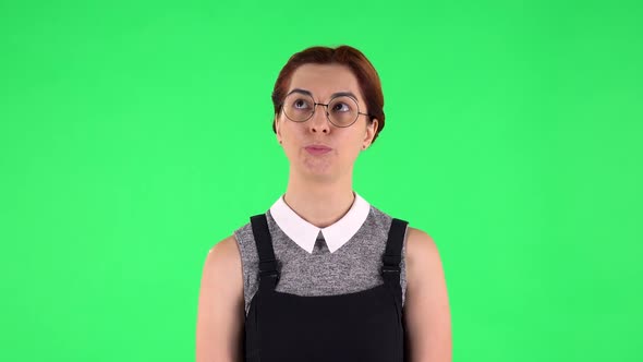 Portrait of Funny Girl in Round Glasses Is Waiting with Boredom. Green Screen