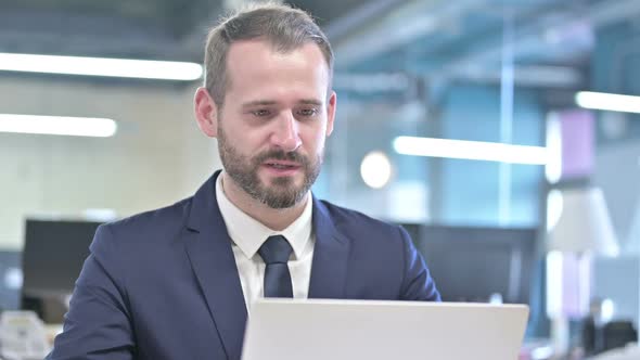 Portrait of Young Businessman Doing Video Chat on Laptop