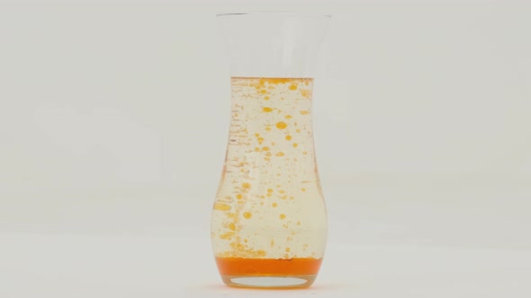 Orange lava lamp effect in a glass vase on white background