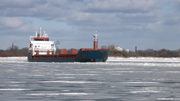 Cargo Ship Sailing Through Frozen Sea Ice In Winter