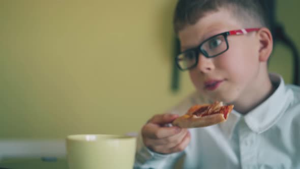 Boy in Shirt Has Lunch with Pizza Near Classmate in Canteen