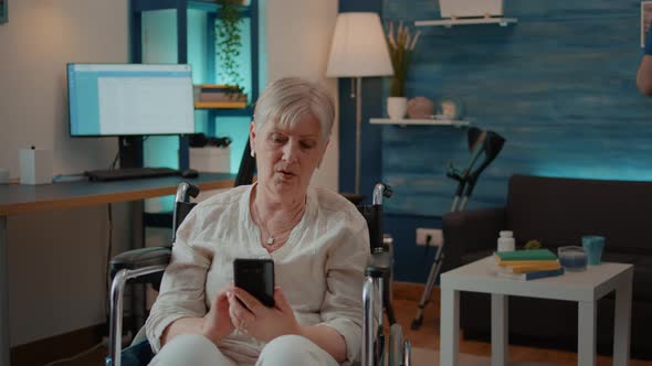 Senior Adult with Disability Browsing Internet on Smartphone