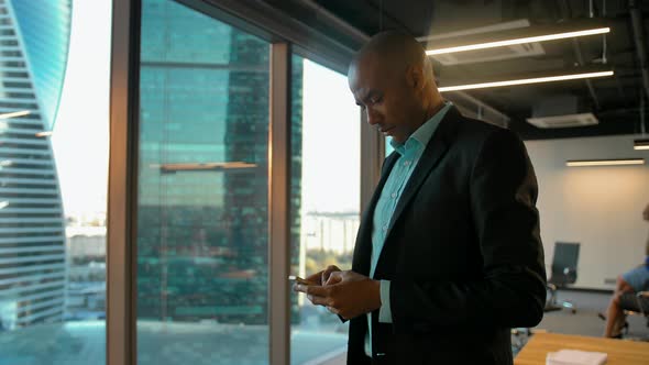 African American Businessman in Formal Clothes Chatting in Messenger with Smartphone.