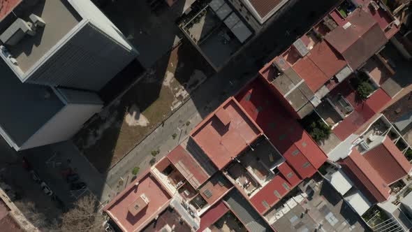 AERIAL: Close Overhead Drone Shot of Barcelona, Spain Rooftops in Sunlight with Traffic on Streets 