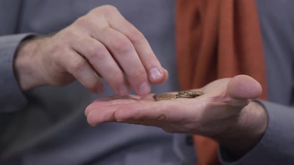 Extreme Close-up of Mature Caucasian Hands Examining Coins. Unrecognizable Numismatist Holding Money