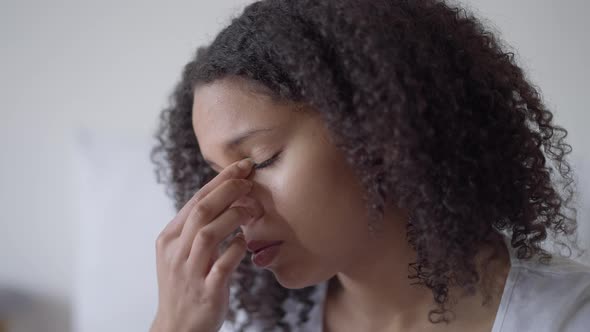 Closeup of Tired Beautiful African American Woman Rubbing Eyes Working at Home Office Indoors