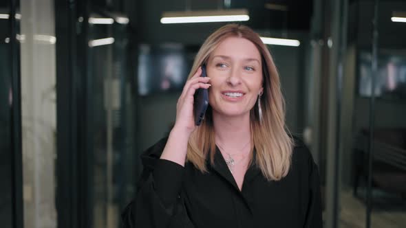 Smiling Businesswoman Looking on Cellphone Indoors