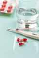 Pills and a glass of water on a light blue background. - PhotoDune Item for Sale