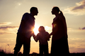 Happy family standing in the park at the sunset time. - PhotoDune Item for Sale